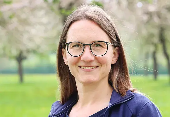 Portrait von Sara Hackspacher, Leiterin der Abteilung Landwirtschaft vor einer Wiese