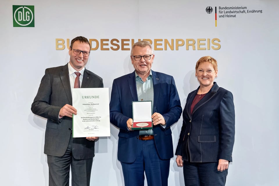 BMLEH-Abteilungsleiterin Christel Jagst (rechts) und DLG-Vizepräsident Ulrich Westrup (links) überreichten gemeinsam auf dem Berliner Milchforum Urkunde und Medaille vom Bundesehrenpreis an Martin Boschet.