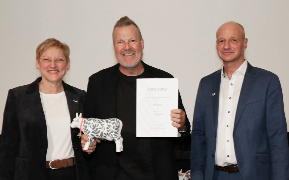 Rolf Stäcker nimmt die Ehrenurkunde von Ministerialdirektorin Christel Jagst vom Bundesministerium für Landwirtschaft, Ernährung und Heimat (BMLEH) und Claus Wiegert (Vorsitzender Zentralverband Deutscher Milchwirtschaftler) entgegen.