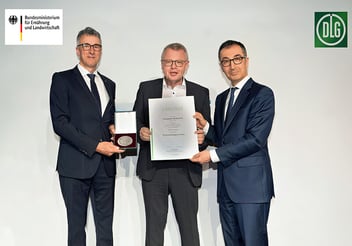 Bundesminister Cem Özdemir überreicht Urkunde und Medaille gemeinsam mit DLG-Vizepräsident René Döbelt auf dem 14. Berliner Milchforum an Martin Boschet.