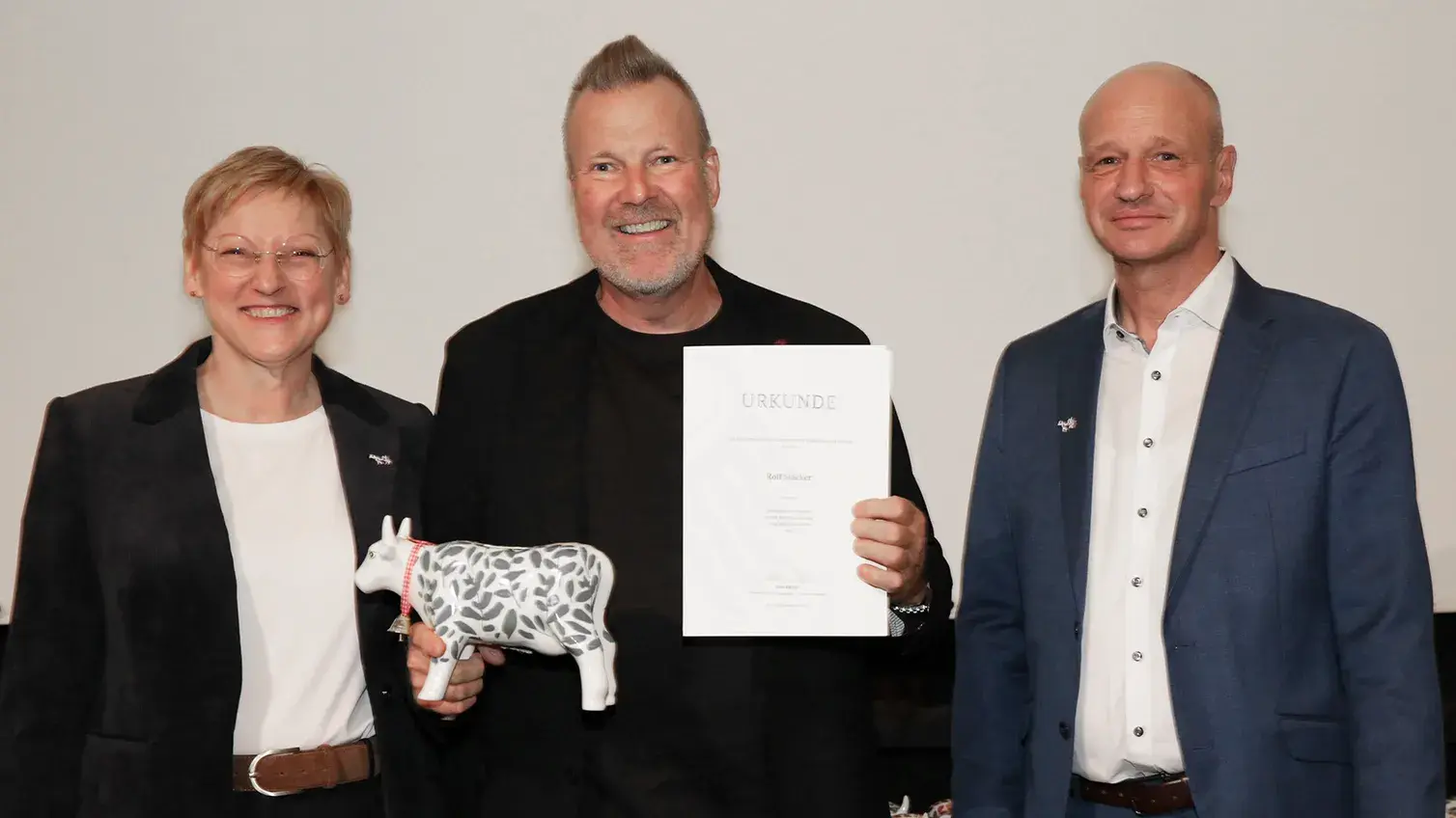 Rolf Stäcker nimmt die Ehrenurkunde von Christel Jagst (Ministerialdirektorin im Bundesministerium für Landwirtschaft, Ernährung und Heimat) und Claus Wiegert (Vorsitzender Zentralverband Deutscher Milchwirtschaftler) entgegen.