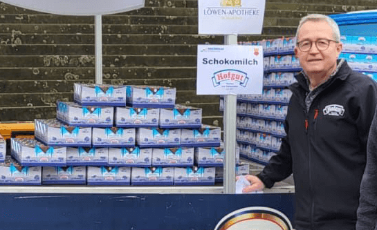 Herr Jürgen Wiedenmann von der Hohenloher Molkerei neben dem Versorgungsstand für die Teilnehmenden des Dreikönigslaufs. Hier gab es für die Läufer und Läuferinnen einen Extra-Schoko-Kick mit der SchokoMilch oder dem SchokoTrunk von Hofgut.