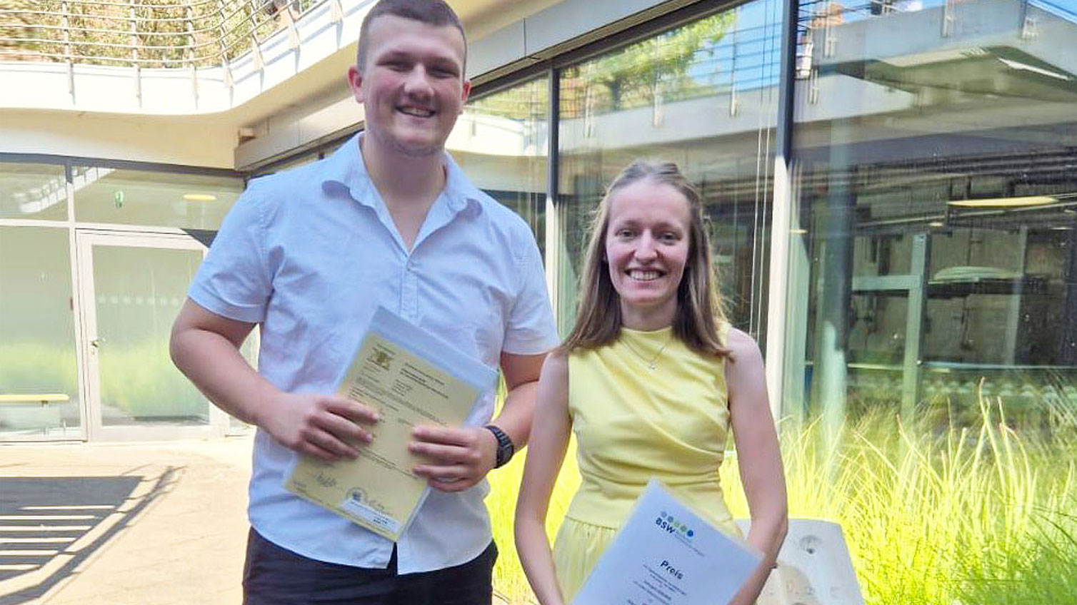 Klara Stadelmaier und San Luca Schirmer mit ihren Urkunden nach bestandener Berufsabschlussprüfung.